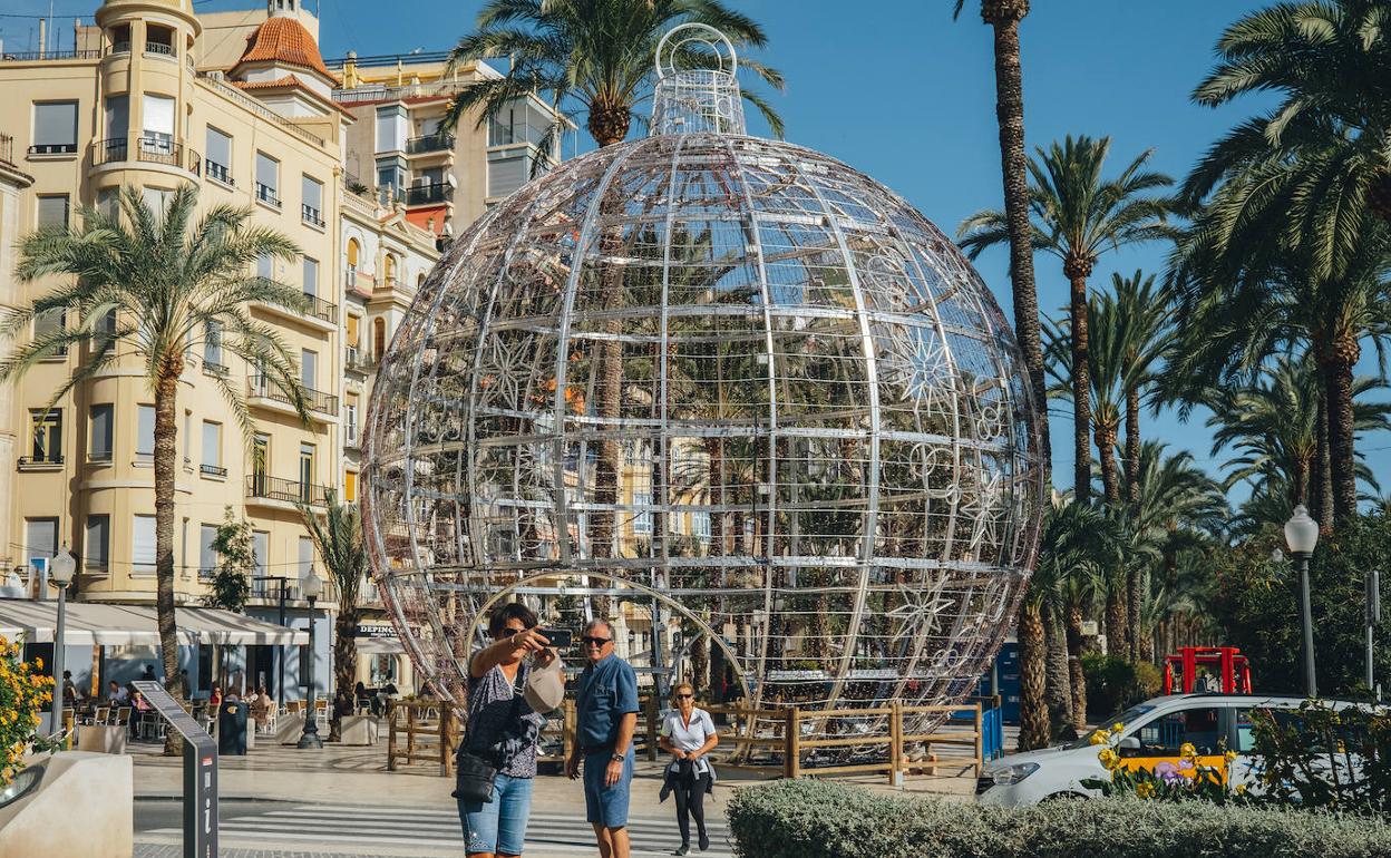 Dos turistas se hacen un 'selfie' con la bola gigante de la Explanada.