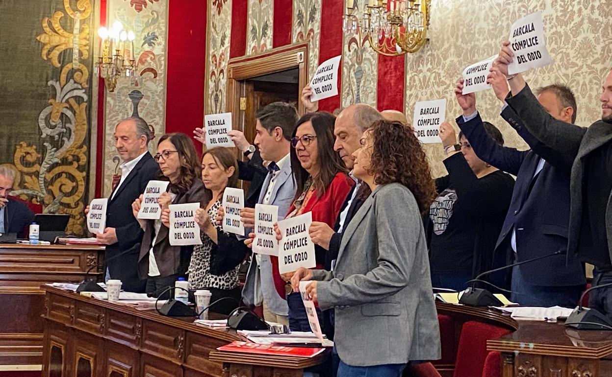 La bancada de la izquierda sujeta los carteles «Barcala, cómplica del odio» al inicio del pleno.