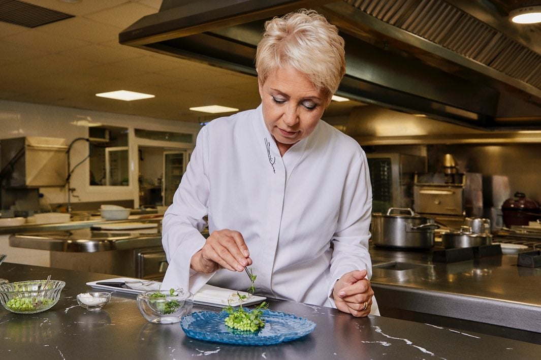 La chef de La Finca cocinando un plato de guisantes. 