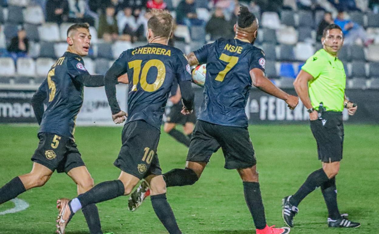 Nsue coge el balón tras conseguir el tanto del empate en compañía de Bellotti y Herrera. 