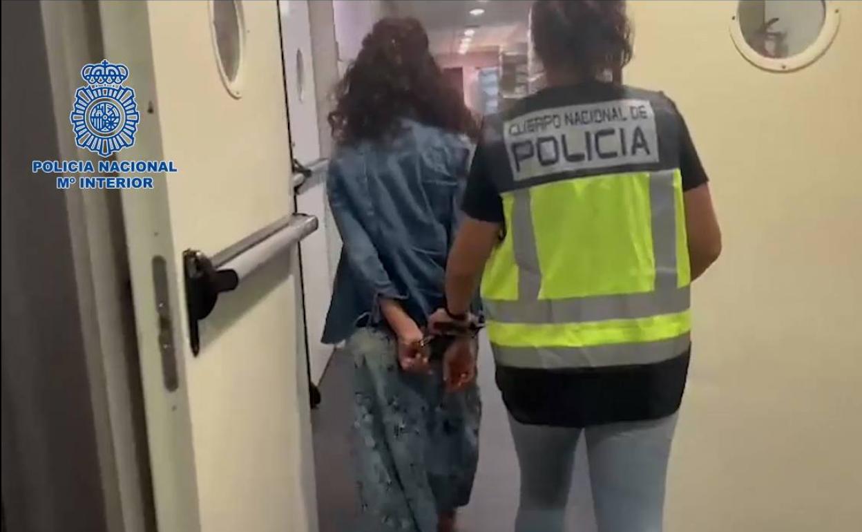 Una agente de Policía Nacional custodia a una detenida en la operación