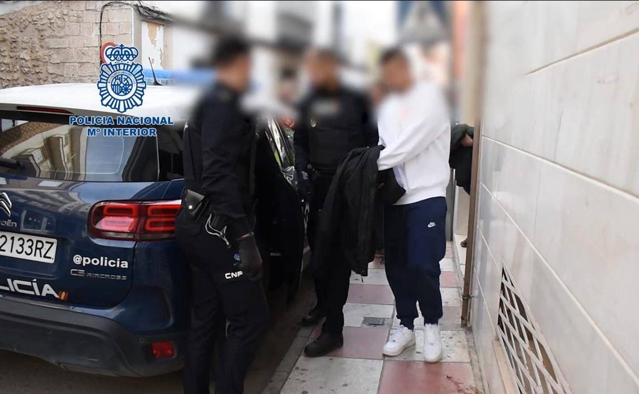 Uno de los detenidos en la operación es trasladado por los agentes de la Policía Nacional.