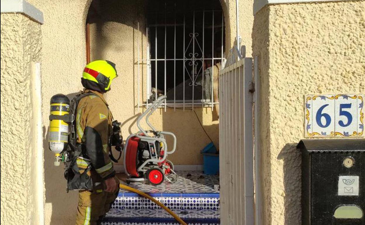 Un bombero, delante del inmueble siniestrado en San Fulgencio.