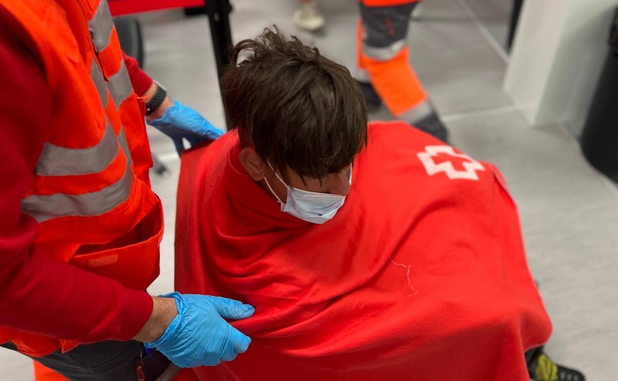 Una persona atendida por la Cruz Roja en silla de ruedas. 