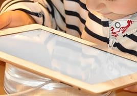 Un niño utiliza utiliza un dispositivo electrónico.