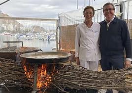 Paco Gandia y su mujer, Josefa, ante una paella cocinada a la brasa.