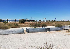 Secciones de valla apiladas en los terrenos de Cala Mosca.