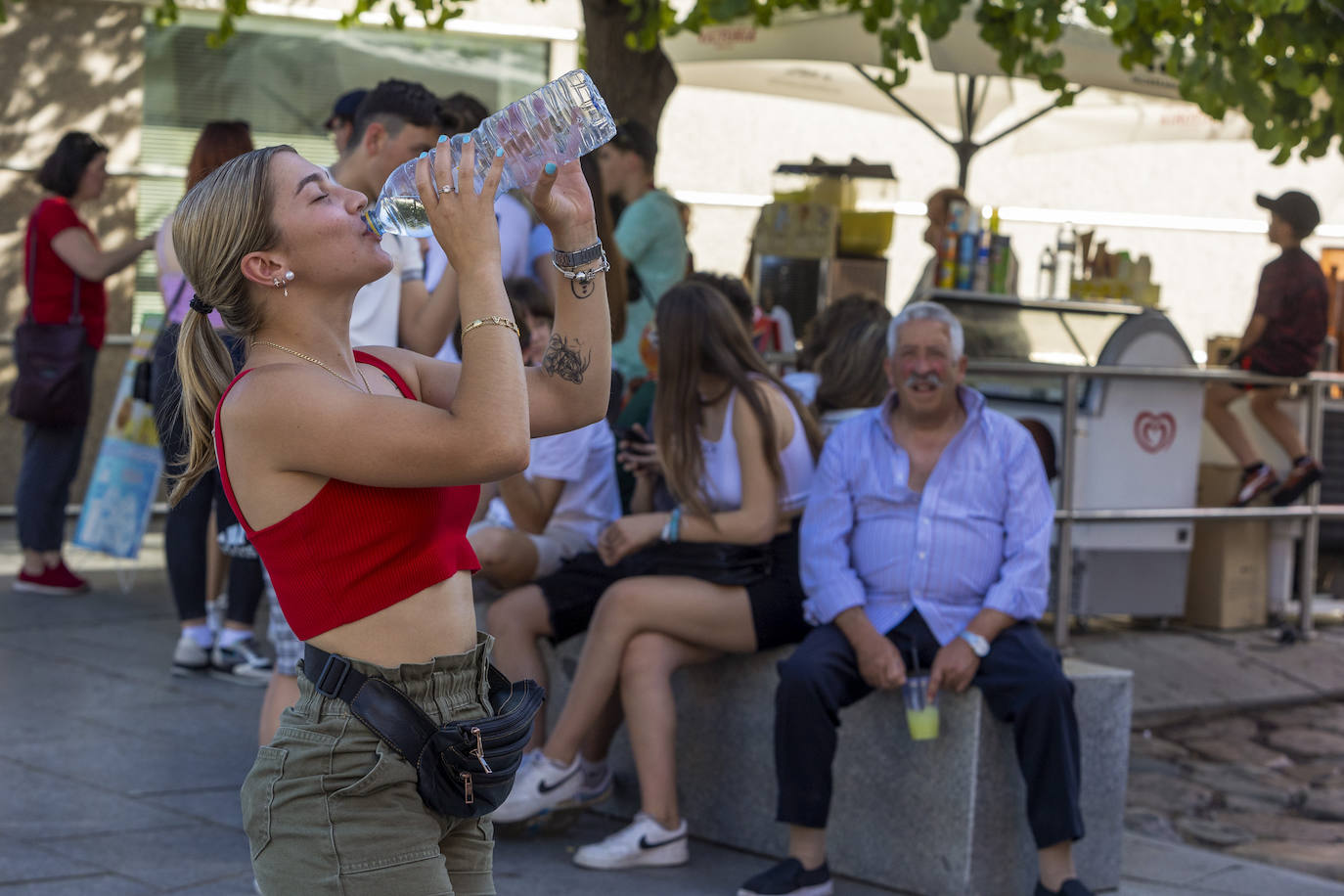 Una mujer bebe agua ante el sofocante calor del mes de abril.