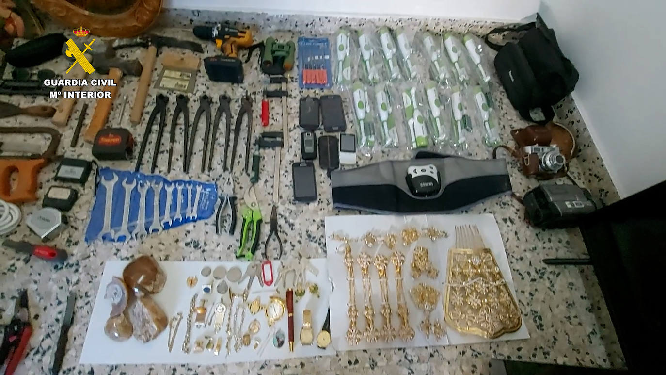 Imagen principal - Material decomisado; un agente durante un registro y el líquido corrosivo utilizado en los robos.