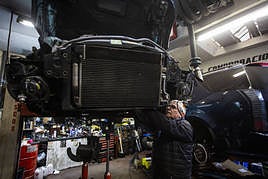 Un mecánico trabaja en su taller reparando un coche