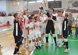 El capitán del equipo levanta la copa con todo el equipo del CD Paidos.