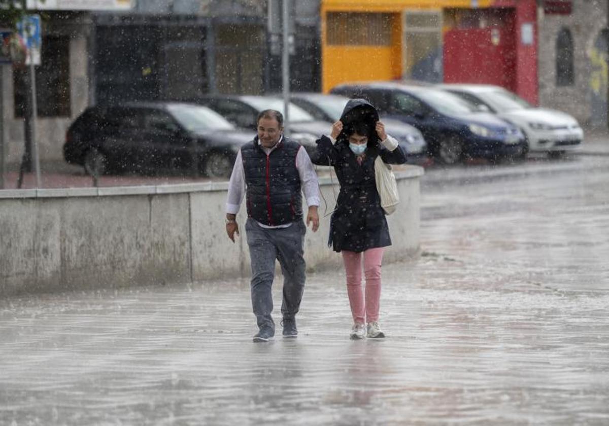 Dos personas bajo la lluvia.