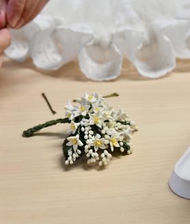 Imagen secundaria 2 - 1. Mantilla, azahar y ganchos de esta bellea. 2. Marisol quita los cilindros de papel y las pinzas que los sujetan de la parte alta de esta prenda 3. La flor del azahar.