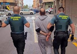 El sospechoso, detenido y custodiado por dos guardias civiles.