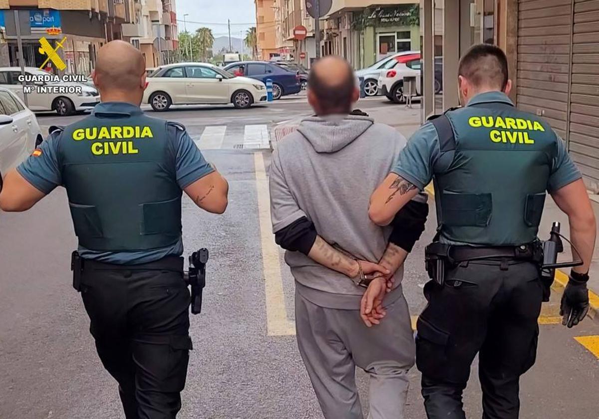 El sospechoso, detenido y custodiado por dos guardias civiles.