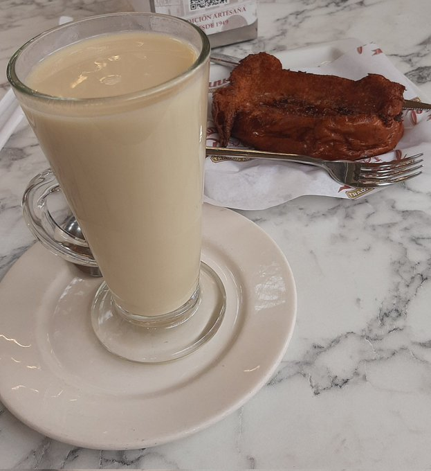 Un vaso de horchata con una torrija de esta misma bebida.