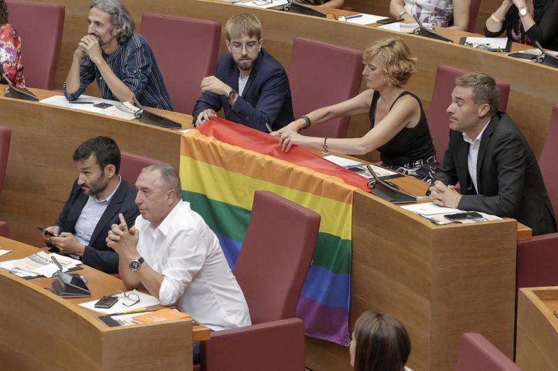Diputados de Compromís exhiben una bandera LGTBi desde sus escaños en Les Corts.
