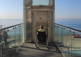 Una persona en silla de ruedas intenta acceder al ascensor averiado.