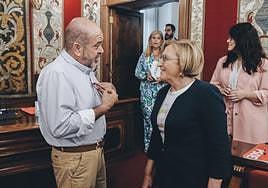 La portavoz socialista, Ana Barceló habla con su compañero Miguel Castelló en el salón de plenos, al fondo los concejales de Vox Carmen Robledillo y Mario Ortolá.