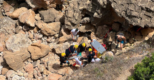 Los bomberos rescatan al herido en la cala de Aigua Dolç.