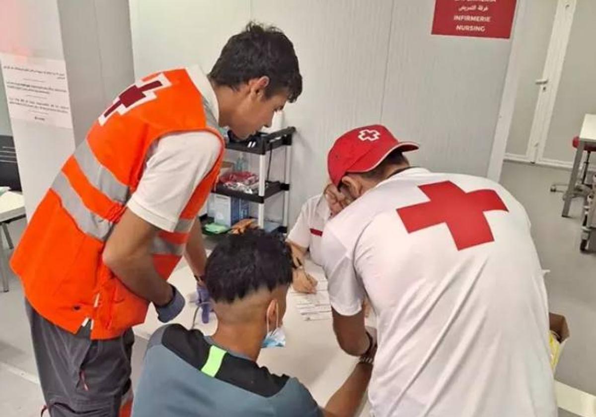 Los trabajadores de Cruz Roja atendiendo a uno de los migrantes en Alicante.