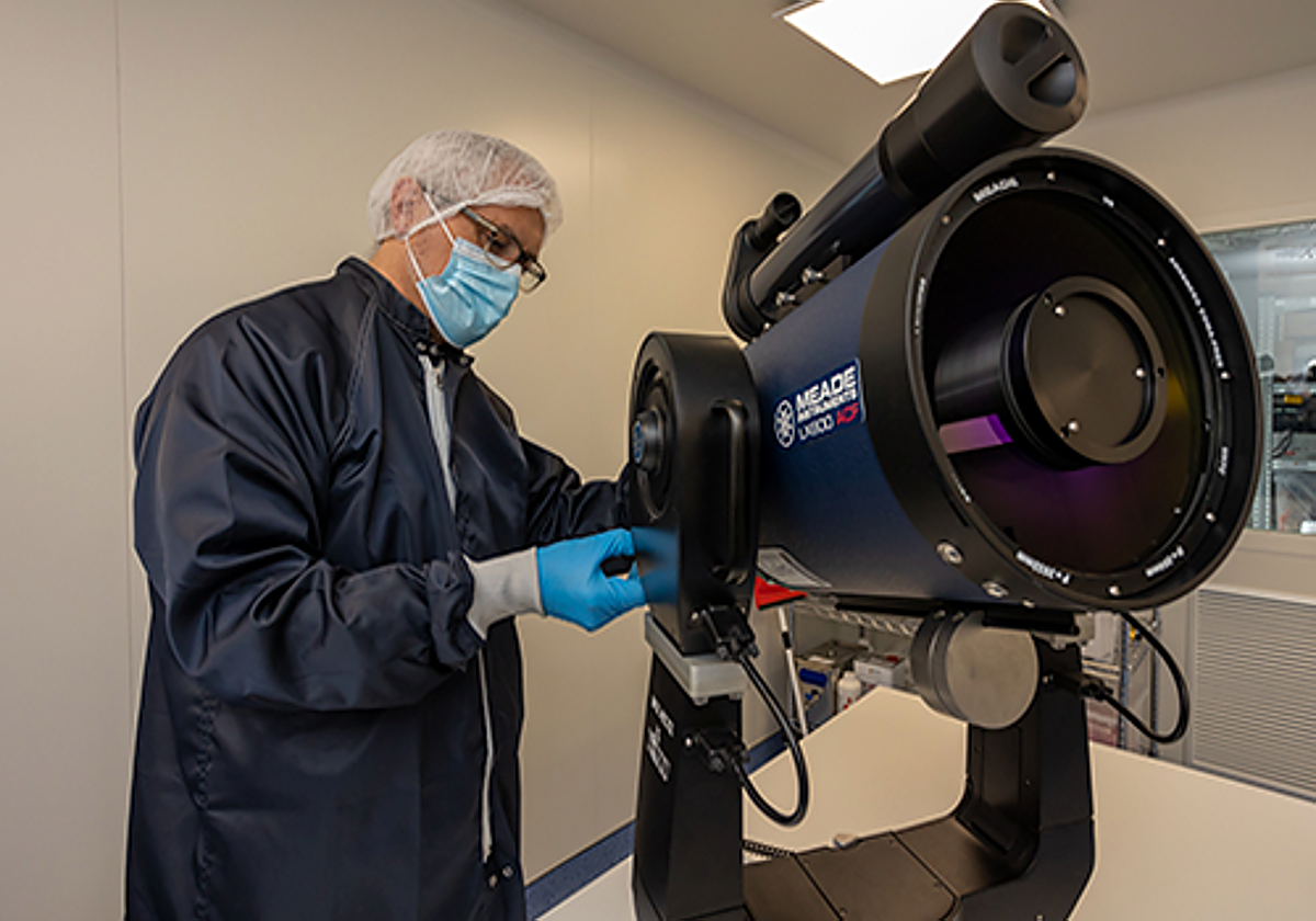 Un investigador de la empresa junto a un telescopio