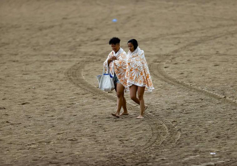 Dos personas en la playa tras las lluvias del martes.