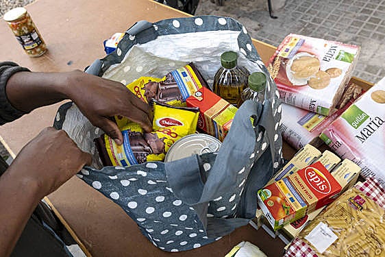 Una persona recibe comida de un banco de alimentos.