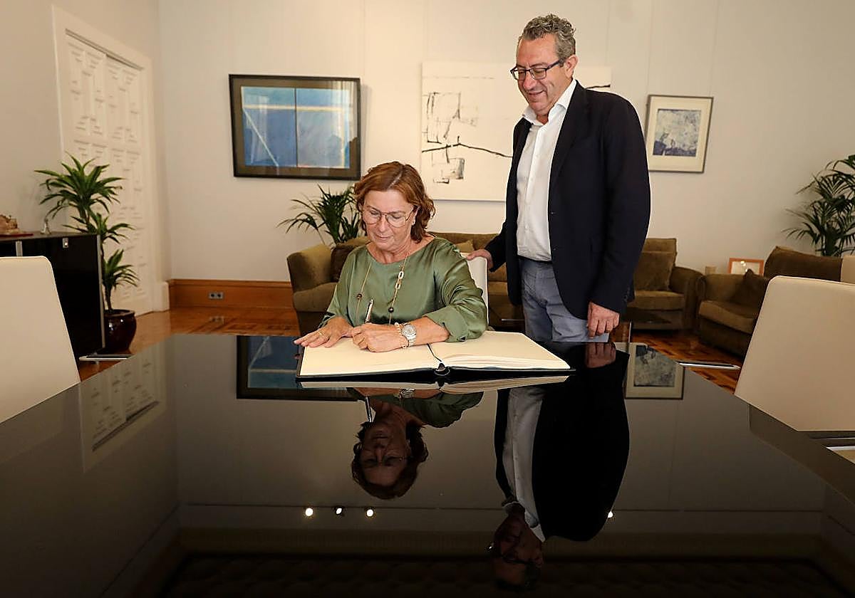 La delegada del Consell, Agustina Esteve, firma en el Libro de Honor de la Diputación Provincial de Alicante, en presencia de su presidente, Toni Pérez.