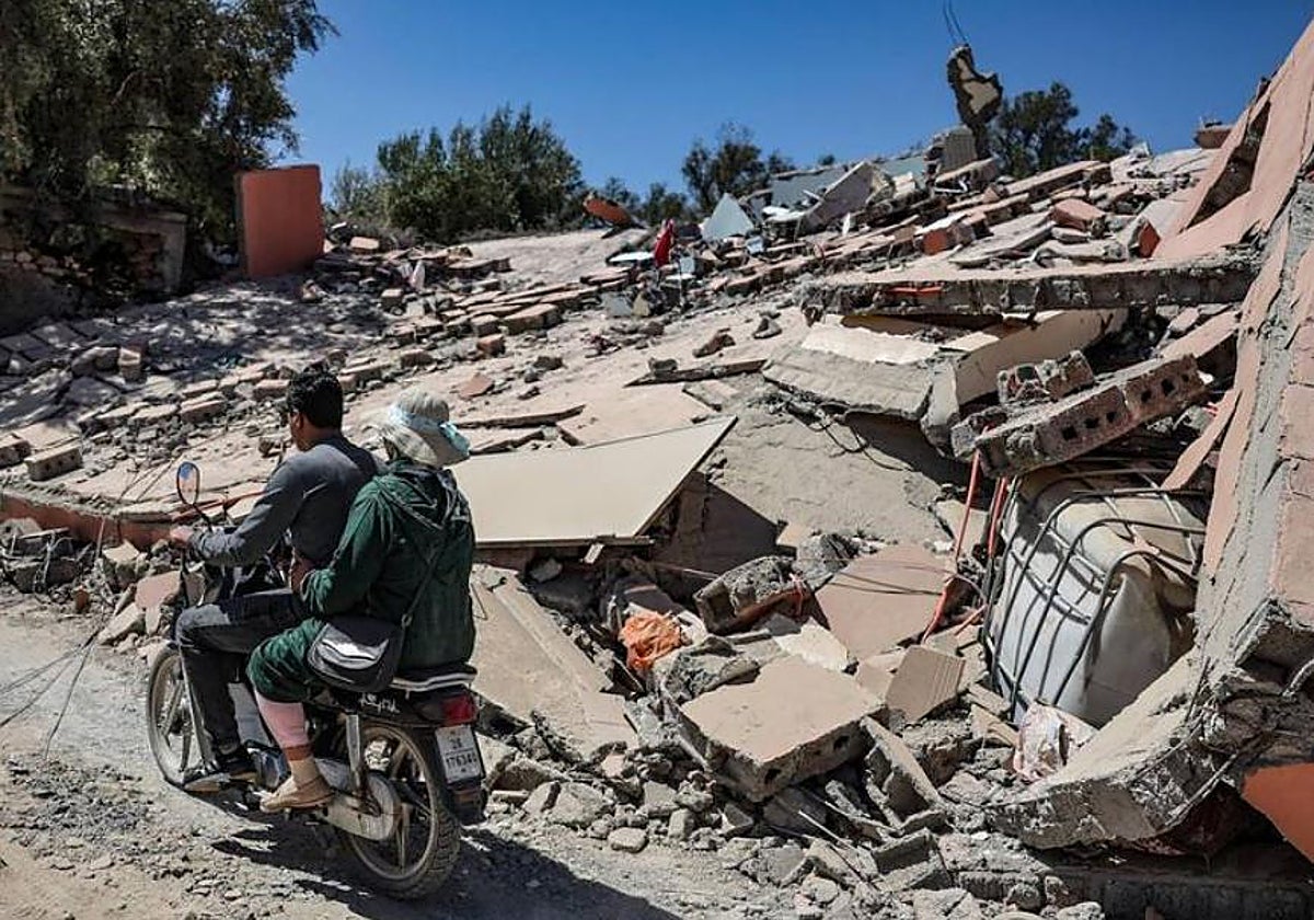 Ciudadanos de una aldea cercana a Marrakech pasa frente a una casa