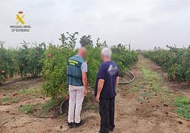 Uno de los agentes de la Guardia Civil junto al dueño de la finca donde fueron sustraídas las granadas