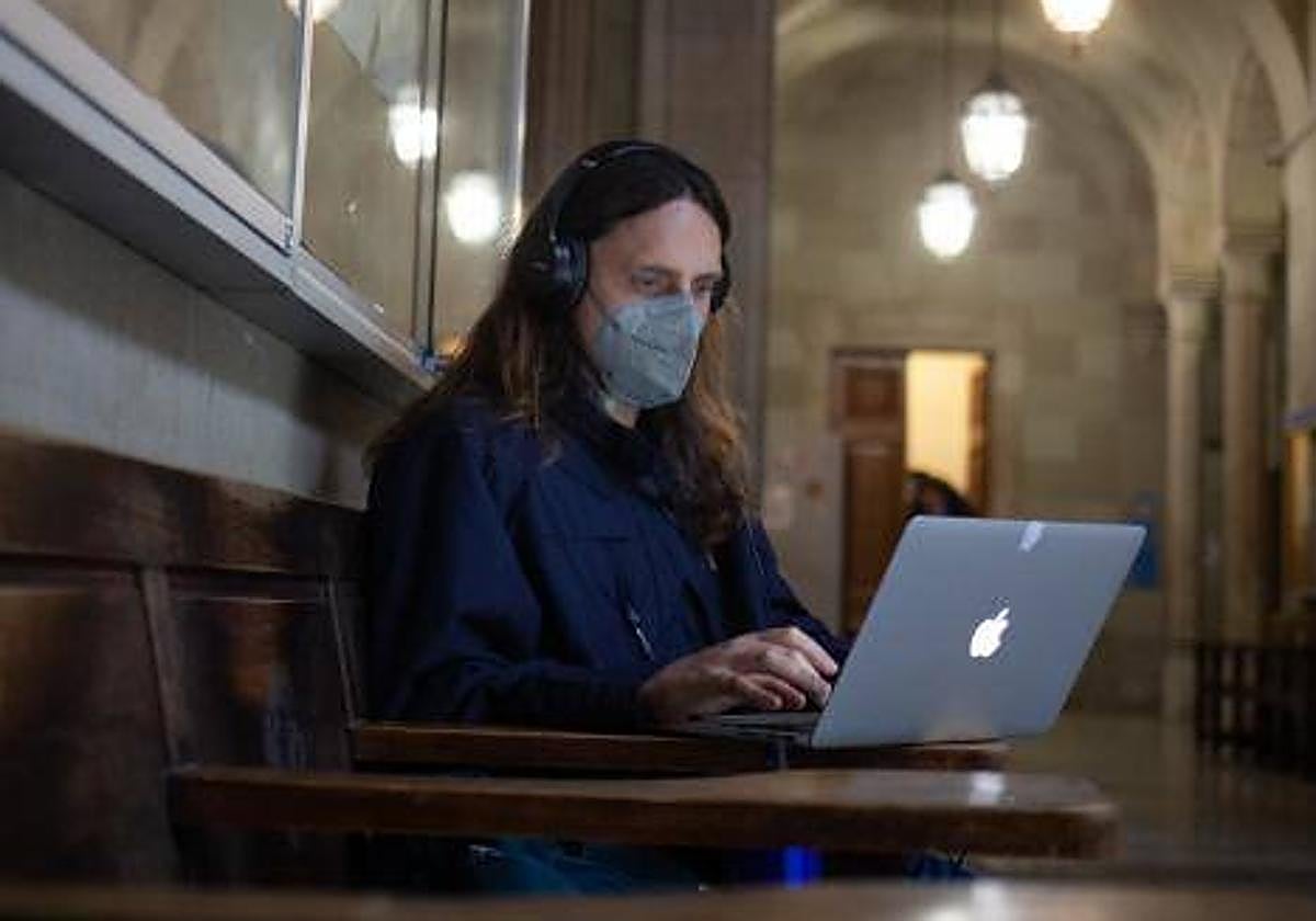 Un hombre consulta su portátil.