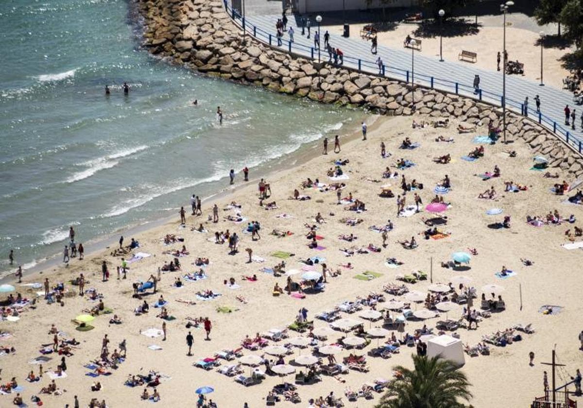 La playa del Postiguet, con gente tomando el sol y bañándose.