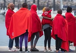 Un grupo de inmigrantes es atetenido por miembros de la Curz Roja.