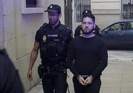 Dos agentes de la Policia Nacional escoltan al acusado antes del juicio.