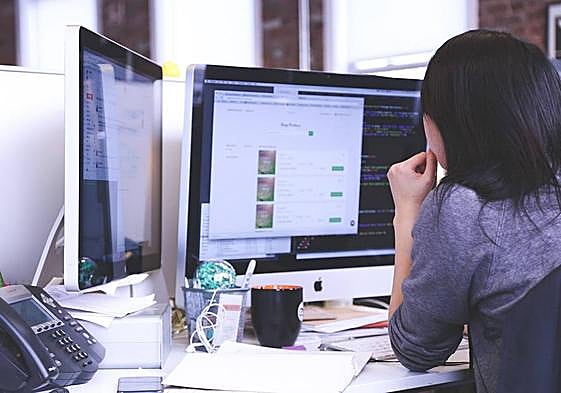 Una persona trabaja con varias pantallas.