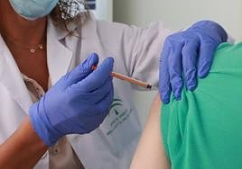 Un hombre se vacuna contra la gripe y la covid.