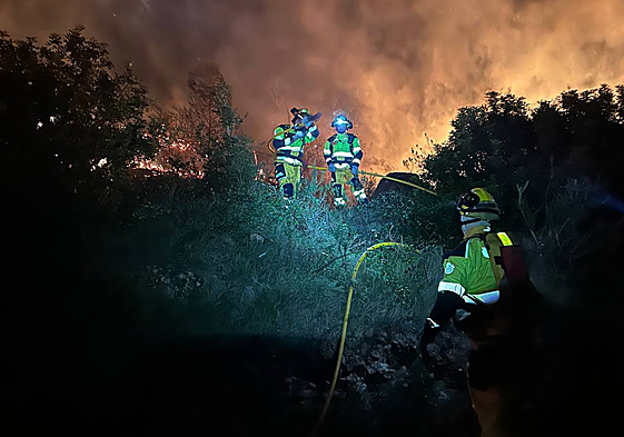 Los bomberos contienen las llamas del incendio.