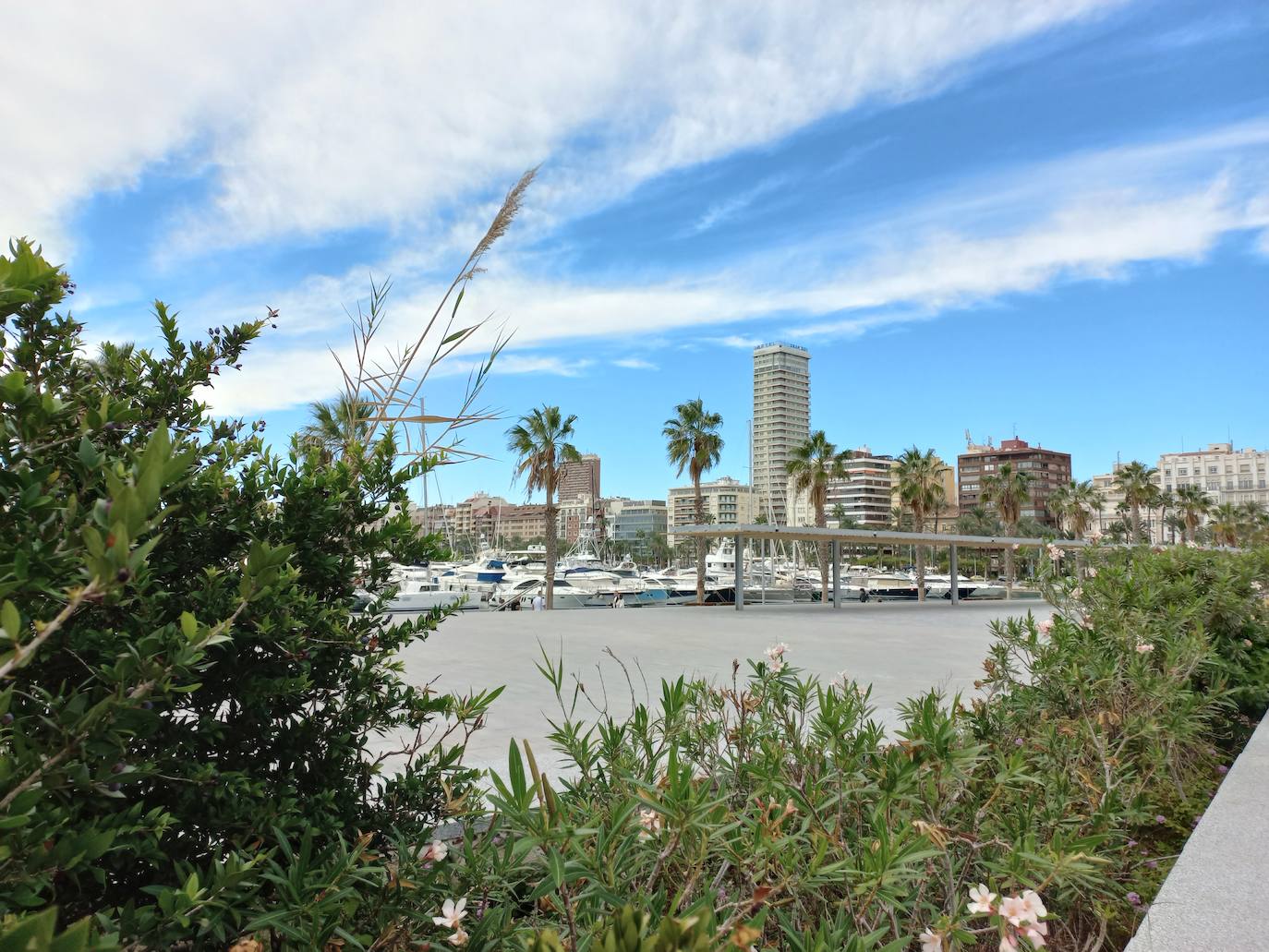 Cielo soleado con presencia de nubes dispersas en el puerto de Alicante.