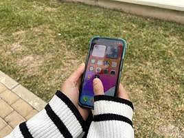 Una joven con un móvil en las manos.