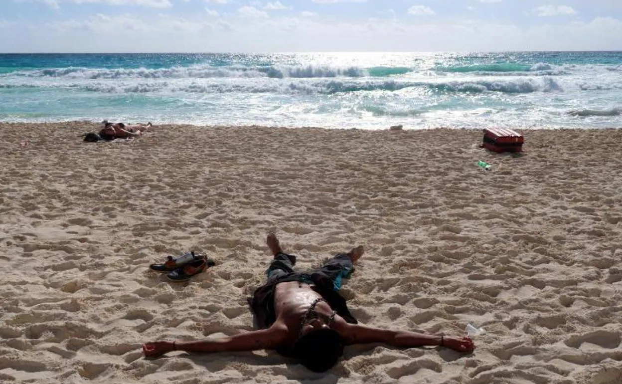 Un hombre tumbado al sol durante sus vacaciones.