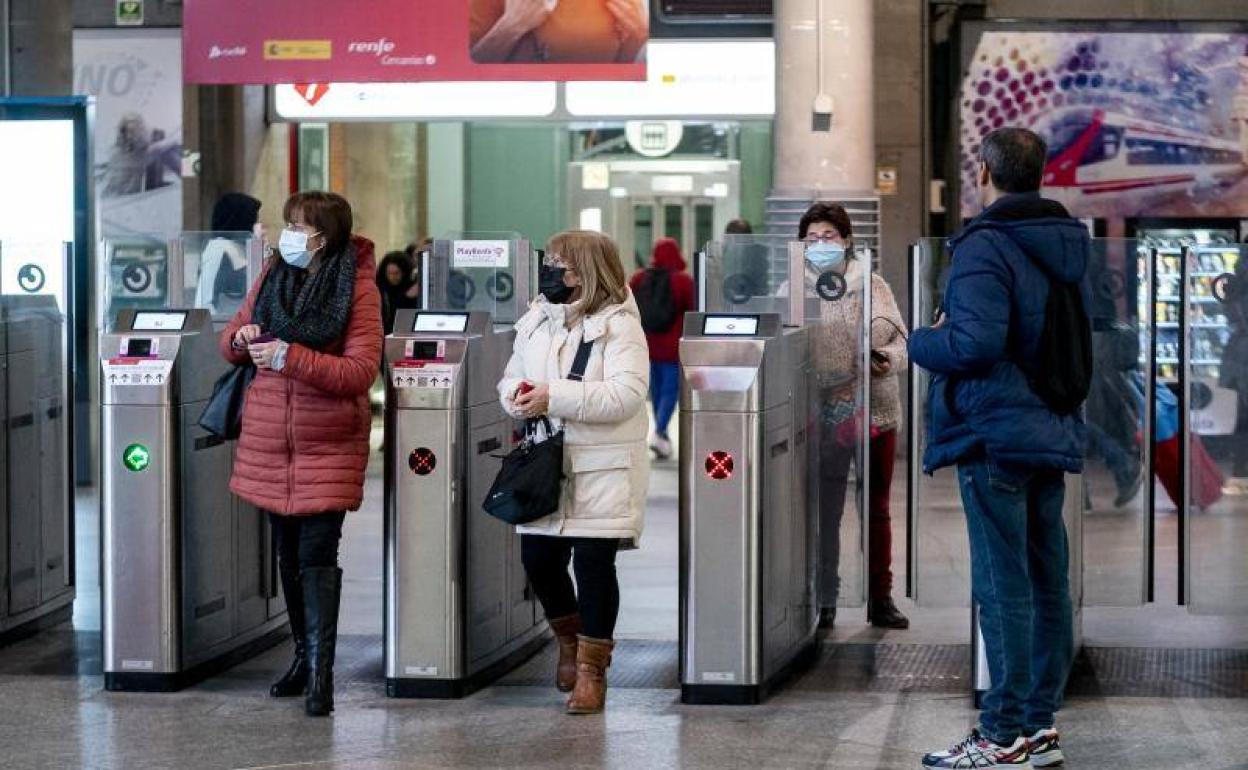 Varias personas con mascarilla salen de los trenes de Cercanías.