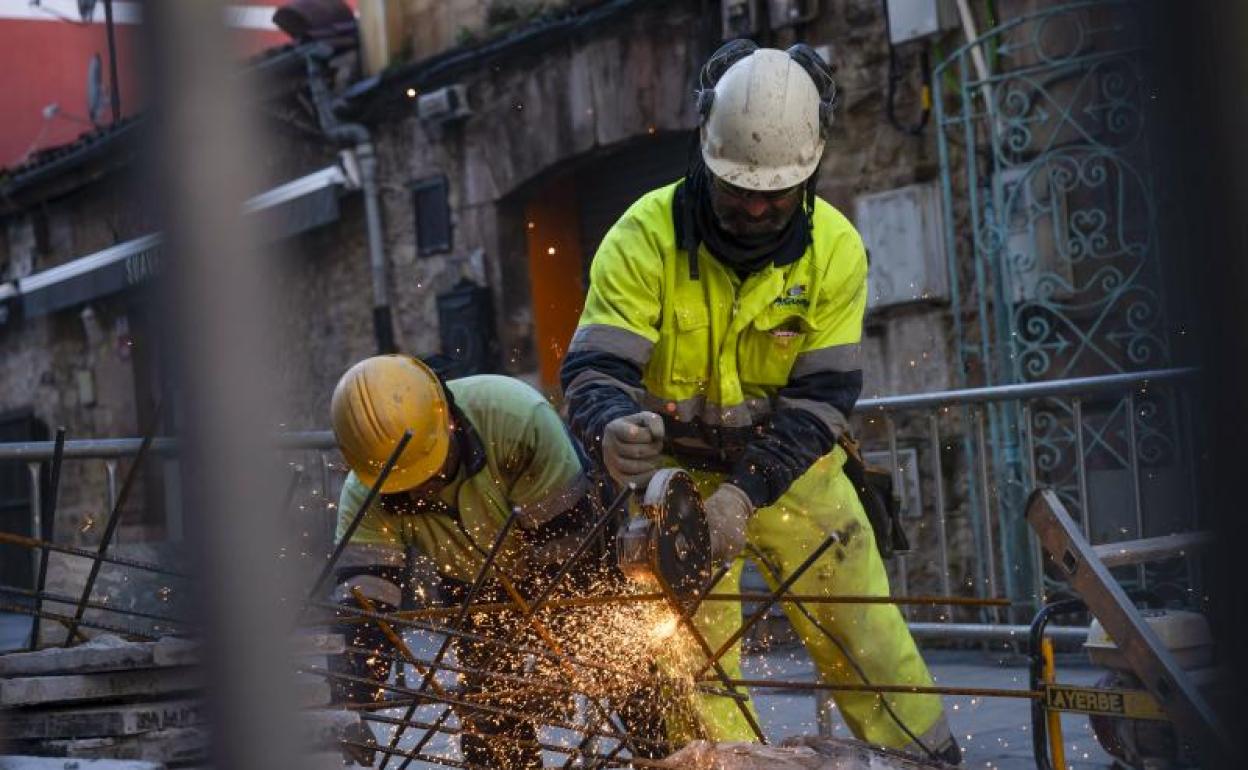 Dos personas trabajan en una calle. 