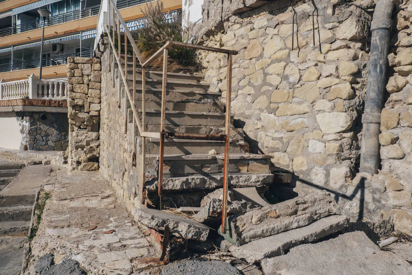 Destrozos en las escaleras de acceso a la playa que no se han arreglado desde el temporal Gloria de 2020. 