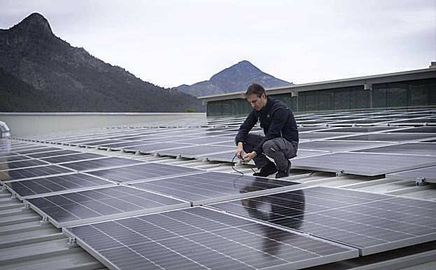 Trabajador de Mercadona en la cubierta de una tienda con placas solares. 