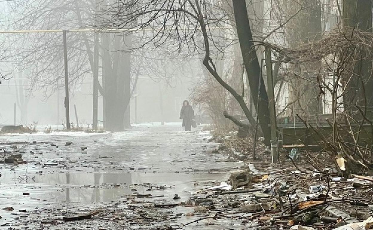Una vecina camina entre la niebla por una calle encharcada y ruinosa de Chasiv Yar, en la misma línea del frente que divide a las tropas ucranianas y rusas.