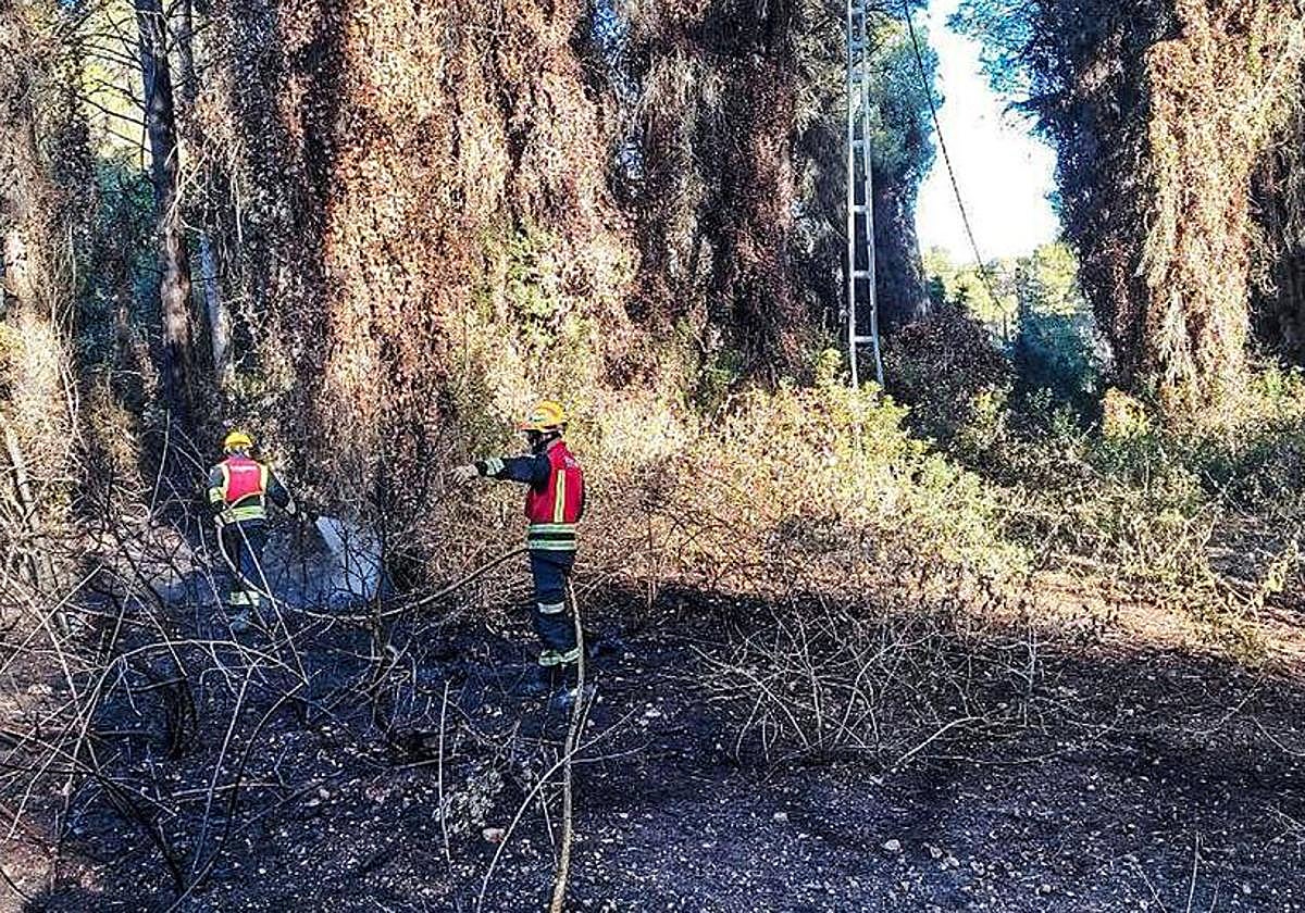 Dos bomberos culminando las tareas de extinción en Xàbia.