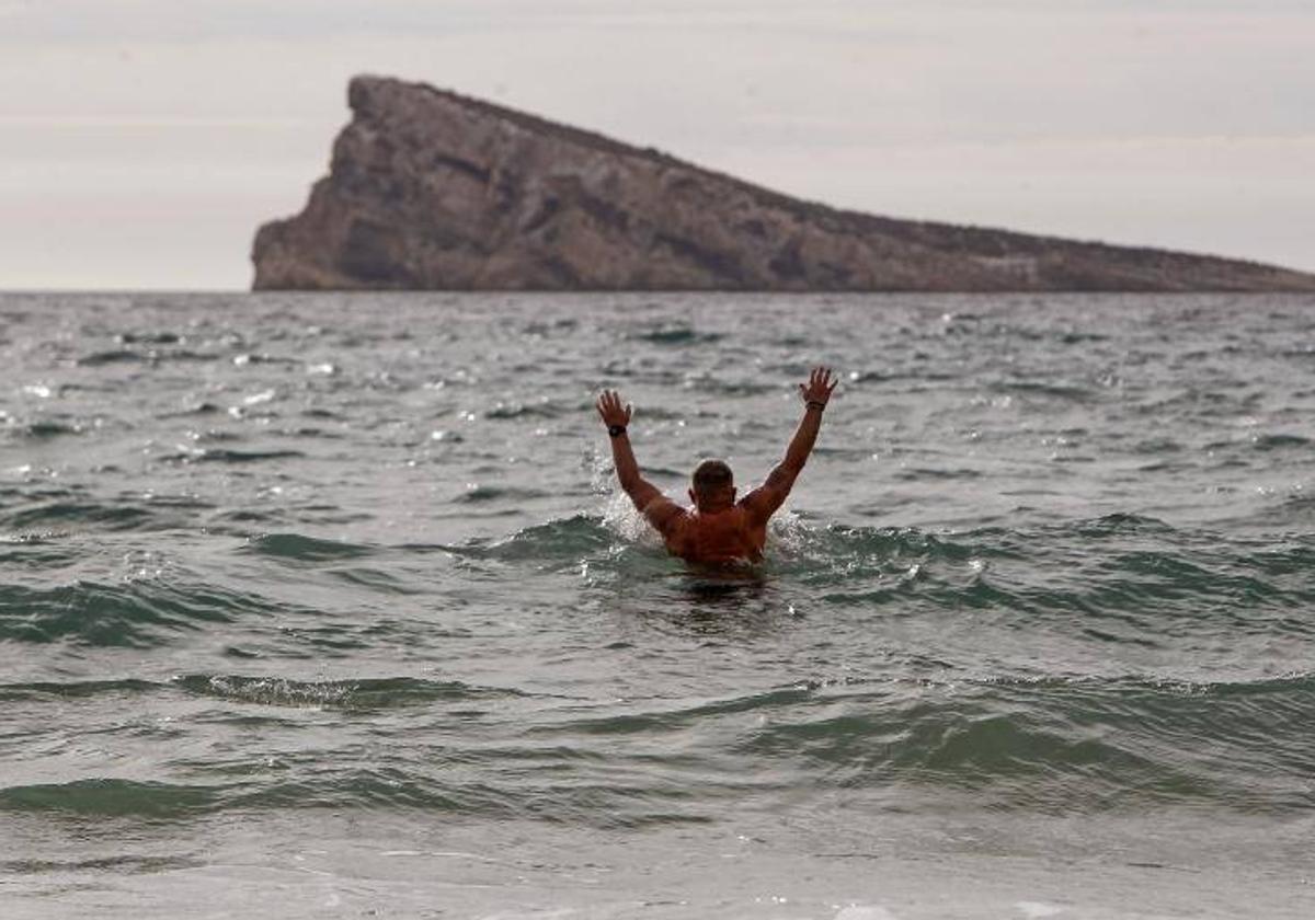 Un hombre se baña en la playa de Levante de Benidorm.