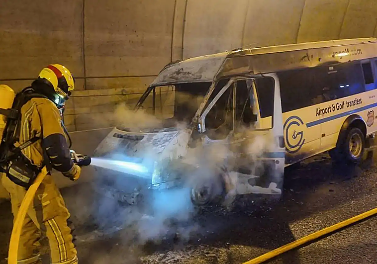 Una dotación de bomberos apagan las llamas de la furgoneta incendiada en el túnel de Pilar de la Horadada.