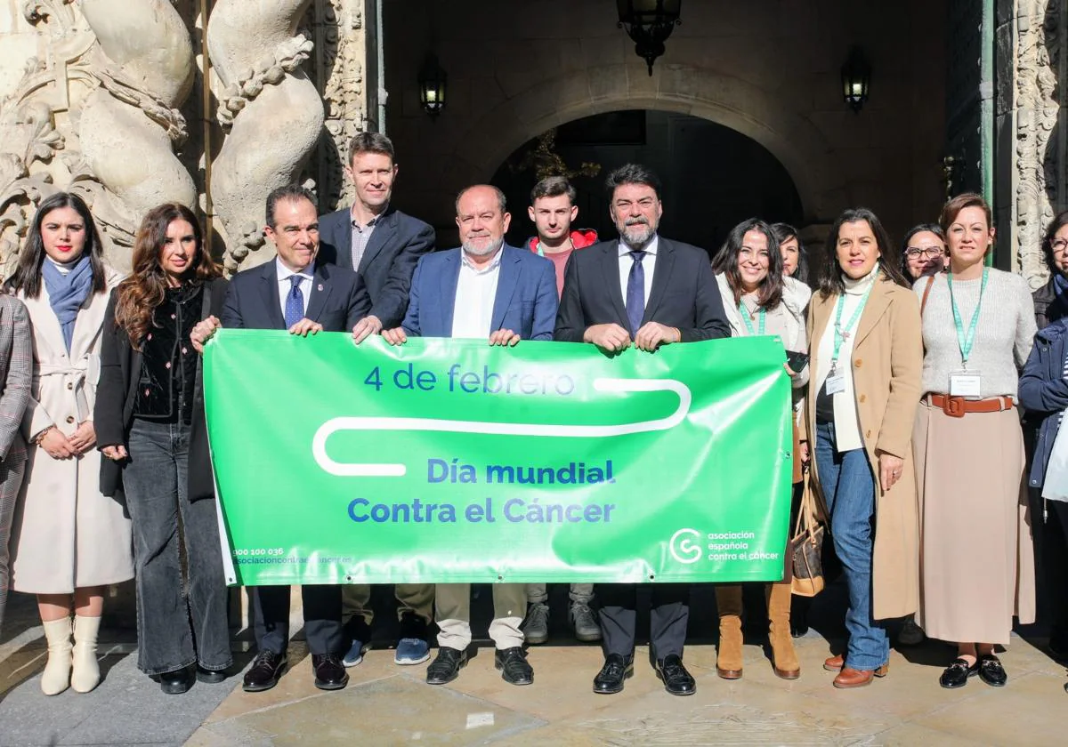Miembros de la corporación municipal de Alicante muestran una pancarta para visibilizar la lucha contra el cáncer.